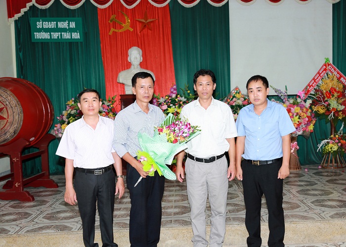 Đ/c Lê Thanh Huyền - Hiệu trưởng nhà trường tặng hoa và trao quyết định nghỉ hưu cho thầy Nguyễn Văn Bình